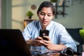 Young Indian Business woman using mobile during working in front of laptop - concept of taking break, chatting, mobile Royalty Free Stock Photo