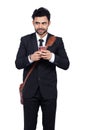 Young Indian businessman smiling while using a mobile phone isolated on white background Royalty Free Stock Photo