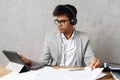 Young indian businessman using tablet and headphones working in office Royalty Free Stock Photo
