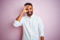 Young indian businessman wearing elegant shirt standing over isolated pink background doing ok gesture with hand smiling, eye Royalty Free Stock Photo