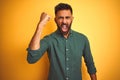 Young indian businessman wearing elegant shirt standing over isolated white background angry and mad raising fist frustrated and Royalty Free Stock Photo