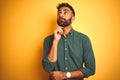 Young indian businessman wearing elegant shirt standing over isolated white background with hand on chin thinking about question, Royalty Free Stock Photo