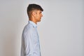 Young indian businessman wearing elegant shirt standing over isolated white background looking to side, relax profile pose with Royalty Free Stock Photo