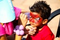 Young Indian child getting a Spiderman face paint mask at festival Royalty Free Stock Photo