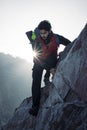 Young indian climber and traveler climbing up the mountain rock during sunset. Adventure and sports concept Royalty Free Stock Photo