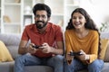 Young Indian Couple Playing Video Games With Joysticks At Home Royalty Free Stock Photo