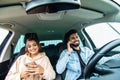 Young indian couple on the red car, man using moblie phones while drive car Royalty Free Stock Photo