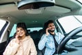 Young indian couple on the red car, man using moblie phones while drive car Royalty Free Stock Photo