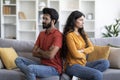 Young Indian Couple Sitting Back To Back On Couch At Home Royalty Free Stock Photo