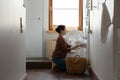 Young indian ethnic woman folding laundry in washing machine. Royalty Free Stock Photo