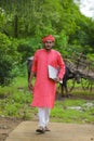 Young indian farmer with laptop at field