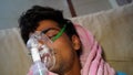 Young Indian farmer taking Emergency Oxygen with Cannula. Severe causes due to Covid in India concept