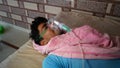 Young Indian farmer taking Emergency Oxygen with Cannula. Severe causes due to Covid in India concept