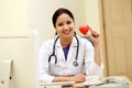 Young Indian female doctor holding red heart shape Royalty Free Stock Photo