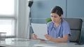 Indian Female Doctor Reading Reports while Sitting in Office Royalty Free Stock Photo