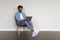 Young Indian Freelancer Guy Using Laptop While Sitting In Armchair At Home Royalty Free Stock Photo