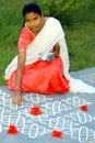 Young indian girl drawing a kolam