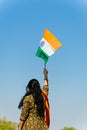 young indian girl holding the indian tricolor national flag waving with bright blue sky at day Royalty Free Stock Photo