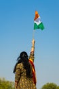 young indian girl holding the indian tricolor national flag waving with bright blue sky at day Royalty Free Stock Photo