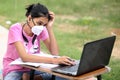 A young Indian girl wearing mask is studying online.