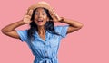 Young indian girl wearing summer hat smiling cheerful playing peek a boo with hands showing face Royalty Free Stock Photo