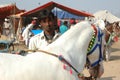 Young indian gypsy nomad with white horse at Pushkar camel fair,India