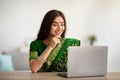 Young Indian lady in beautiful sari dress studying or working online on laptop, indoors Royalty Free Stock Photo