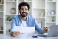 Young Indian Male Working With Papers And Laptop At Home Office Royalty Free Stock Photo