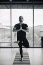 Young Indian man doing a tree pose during yoga practice