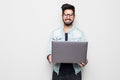 Young indian man in eyesglasses and casual wear holding laptop white standing isolated on white background