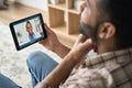 Young indian man having videocall with female black doctor using tablet. Royalty Free Stock Photo