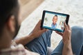 Young indian man having videocall with female black doctor using tablet. Royalty Free Stock Photo