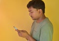 Young Indian man looks at his mobile phone when useing internet Royalty Free Stock Photo