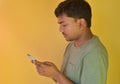 Young Indian man looks at his mobile phone when useing internet