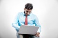 Young Indian man on spectacles and using laptop Royalty Free Stock Photo