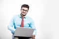 Young Indian man on spectacles and using laptop Royalty Free Stock Photo