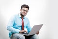 Young Indian man on spectacles and using laptop Royalty Free Stock Photo