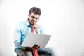 Young Indian man on spectacles and using laptop Royalty Free Stock Photo