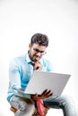 Young Indian man on spectacles and using laptop Royalty Free Stock Photo