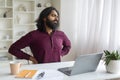 Indian Man Suffering From Backache While Sitting At Desk In Home Office Royalty Free Stock Photo