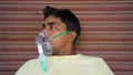Man infected with Covid 19 disease. Patient inhaling oxygen wearing mask with liquid Oxygen flow