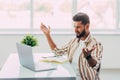 Young happy indian man talking on video conference call greeting waving hand using laptop at modern home office. Remote distant Royalty Free Stock Photo