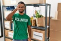 Young indian man volunteer holding donations box doing ok gesture with hand smiling, eye looking through fingers with happy face Royalty Free Stock Photo