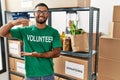 Young indian man volunteer holding donations box gesturing with hands showing big and large size sign, measure symbol Royalty Free Stock Photo