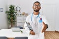 Young indian man wearing doctor uniform and stethoscope smiling friendly offering handshake as greeting and welcoming Royalty Free Stock Photo