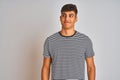 Young indian man wearing navy striped t-shirt standing over isolated white background smiling looking to the side and staring away Royalty Free Stock Photo