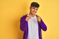 Young indian man wearing purple sweatshirt standing over isolated yellow background pointing fingers to camera with happy and Royalty Free Stock Photo