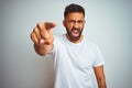 Young indian man wearing t-shirt standing over isolated white background pointing displeased and frustrated to the camera, angry Royalty Free Stock Photo