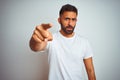 Young indian man wearing t-shirt standing over isolated white background pointing displeased and frustrated to the camera, angry Royalty Free Stock Photo