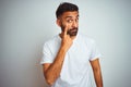 Young indian man wearing t-shirt standing over isolated white background Pointing to the eye watching you gesture, suspicious Royalty Free Stock Photo